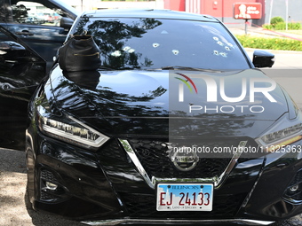 A vehicle is being damaged by bullet holes in the KFC parking lot. Three people are being shot in Chicago, Illinois, United States, on June...