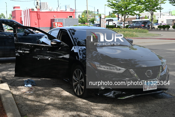 A vehicle is being damaged by bullet holes in the KFC parking lot. Three people are being shot in Chicago, Illinois, United States, on June...