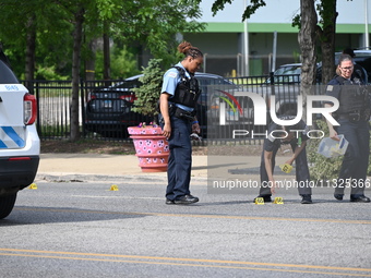 Chicago police and the crime scene unit are investigating the shooting and putting down evidence markers for shell casings, with over 80 evi...