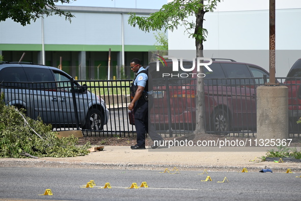 Chicago police and the crime scene unit are investigating the shooting and putting down evidence markers for shell casings, with over 80 evi...