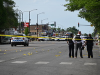 Chicago police and the crime scene unit are investigating the shooting and putting down evidence markers for shell casings, with over 80 evi...