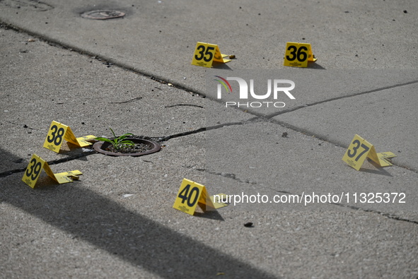 Evidence markers are showing where shell casings are located at the crime scene. Three people are being shot in Chicago, Illinois, United St...