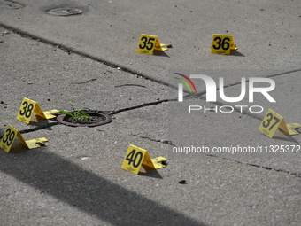 Evidence markers are showing where shell casings are located at the crime scene. Three people are being shot in Chicago, Illinois, United St...