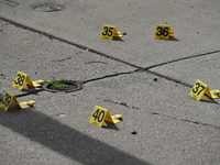 Evidence markers are showing where shell casings are located at the crime scene. Three people are being shot in Chicago, Illinois, United St...