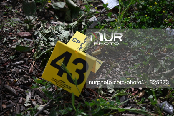 An evidence marker is showing where shell casings are located at the crime scene. Three people are being shot in Chicago, Illinois, United S...