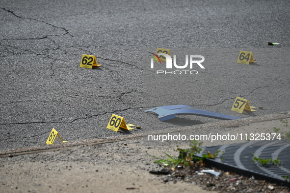 Evidence markers are showing where shell casings are located at the crime scene. Three people are being shot in Chicago, Illinois, United St...