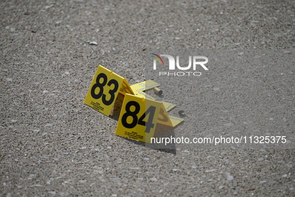 Evidence markers are showing where shell casings are located at the crime scene. Three people are being shot in Chicago, Illinois, United St...