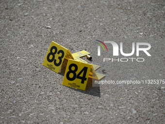 Evidence markers are showing where shell casings are located at the crime scene. Three people are being shot in Chicago, Illinois, United St...