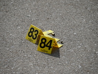 Evidence markers are showing where shell casings are located at the crime scene. Three people are being shot in Chicago, Illinois, United St...