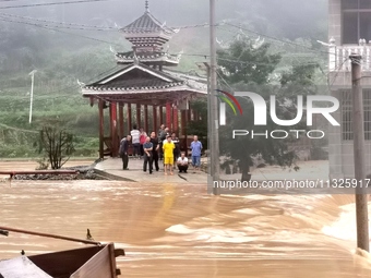 The flood damage is occurring in Gaozhai village, Qiandongnan County, Guizhou province, China, on the morning of June 12, 2024. (