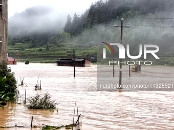 The flood damage is occurring in Gaozhai village, Qiandongnan County, Guizhou province, China, on the morning of June 12, 2024. (