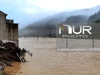 The flood damage is occurring in Gaozhai village, Qiandongnan County, Guizhou province, China, on the morning of June 12, 2024. (