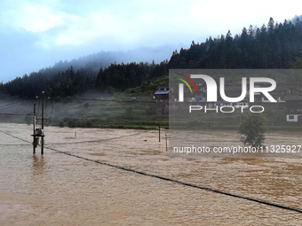 The flood damage is occurring in Gaozhai village, Qiandongnan County, Guizhou province, China, on the morning of June 12, 2024. (