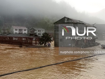 The flood damage is occurring in Gaozhai village, Qiandongnan County, Guizhou province, China, on the morning of June 12, 2024. (