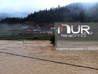 The flood damage is occurring in Gaozhai village, Qiandongnan County, Guizhou province, China, on the morning of June 12, 2024. (