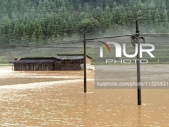 The flood damage is occurring in Gaozhai village, Qiandongnan County, Guizhou province, China, on the morning of June 12, 2024. (