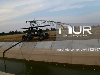 Farmers are using mobile sprinkler irrigation equipment to water newly sown corn in Daqu village in Liaocheng, China, on June 12, 2024. (