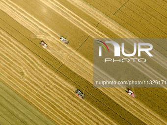 Farmers are driving large harvesting machines to harvest wheat for major growers in Yingcun village, Lianyungang city, Jiangsu province, Chi...