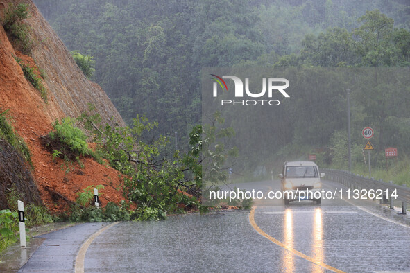 Vehicles are passing through a slope collapse at Sanmatun Road in Liuzhou, China, on June 13, 2024. 