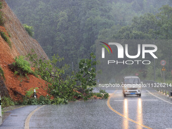 Vehicles are passing through a slope collapse at Sanmatun Road in Liuzhou, China, on June 13, 2024. (