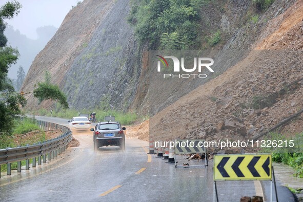 Vehicles are passing through a slope collapse in Dongtan Village, Liuzhou city, South China's Guangxi Zhuang Autonomous region, in Liuzhou,...