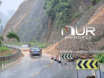 Vehicles are passing through a slope collapse in Dongtan Village, Liuzhou city, South China's Guangxi Zhuang Autonomous region, in Liuzhou,...