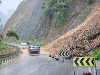 Vehicles are passing through a slope collapse in Dongtan Village, Liuzhou city, South China's Guangxi Zhuang Autonomous region, in Liuzhou,...