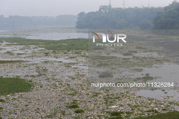 Officers are using an excavator to clean up plastic waste that has settled in the Citarum River in Batujajar, Bandung, West Java, Indonesia,...