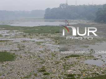 Officers are using an excavator to clean up plastic waste that has settled in the Citarum River in Batujajar, Bandung, West Java, Indonesia,...