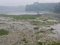 Officers are using an excavator to clean up plastic waste that has settled in the Citarum River in Batujajar, Bandung, West Java, Indonesia,...