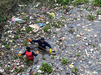 Officers are cleaning up plastic waste that has settled in the Citarum River, Batujajar, Bandung, West Java, Indonesia, on Thursday, June 13...