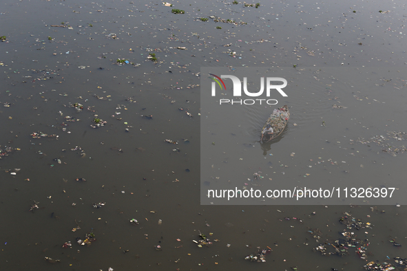 A resident is using a wooden boat to clean plastic waste that has settled in the Citarum River in Batujajar, Bandung, West Java, Indonesia,...