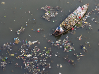 A resident is using a wooden boat to clean plastic waste that has settled in the Citarum River in Batujajar, Bandung, West Java, Indonesia,...