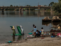 Women are washing clothes on the banks of River Jhelum on a hot summer day in Sopore, Jammu and Kashmir, India, on June 13, 2024. (