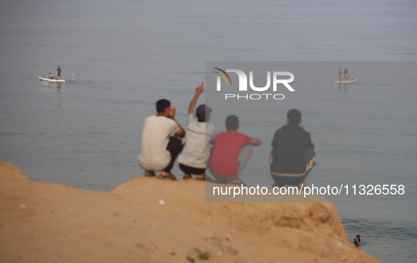 Palestinian fishermen are sailing on a boat in Deir el-Balah, in the central Gaza Strip, on June 13, 2024, amid the ongoing conflict in the...