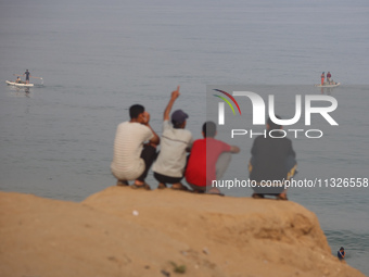 Palestinian fishermen are sailing on a boat in Deir el-Balah, in the central Gaza Strip, on June 13, 2024, amid the ongoing conflict in the...