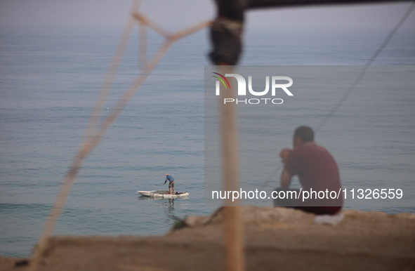 Palestinian fishermen are sailing on a boat in Deir el-Balah, in the central Gaza Strip, on June 13, 2024, amid the ongoing conflict in the...