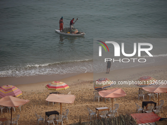 Palestinian fishermen are sailing on a boat in Deir el-Balah, in the central Gaza Strip, on June 13, 2024, amid the ongoing conflict in the...