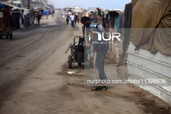 United Nations Agency for Palestinian Refugees (UNRWA) workers are cleaning a street in Deir el-Balah, in the central Gaza Strip, on June 13...