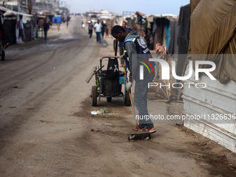 United Nations Agency for Palestinian Refugees (UNRWA) workers are cleaning a street in Deir el-Balah, in the central Gaza Strip, on June 13...