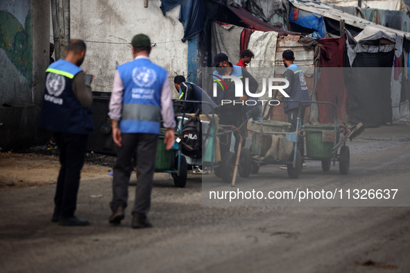 United Nations Agency for Palestinian Refugees (UNRWA) workers are cleaning a street in Deir el-Balah, in the central Gaza Strip, on June 13...