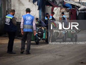 United Nations Agency for Palestinian Refugees (UNRWA) workers are cleaning a street in Deir el-Balah, in the central Gaza Strip, on June 13...