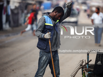 United Nations Agency for Palestinian Refugees (UNRWA) workers are cleaning a street in Deir el-Balah, in the central Gaza Strip, on June 13...