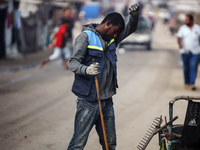 United Nations Agency for Palestinian Refugees (UNRWA) workers are cleaning a street in Deir el-Balah, in the central Gaza Strip, on June 13...