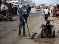 United Nations Agency for Palestinian Refugees (UNRWA) workers are cleaning a street in Deir el-Balah, in the central Gaza Strip, on June 13...