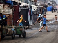 United Nations Agency for Palestinian Refugees (UNRWA) workers are cleaning a street in Deir el-Balah, in the central Gaza Strip, on June 13...