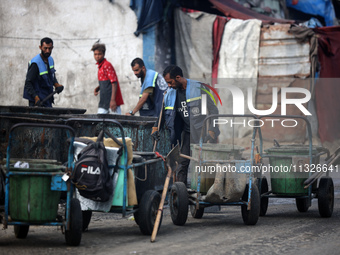 United Nations Agency for Palestinian Refugees (UNRWA) workers are cleaning a street in Deir el-Balah, in the central Gaza Strip, on June 13...