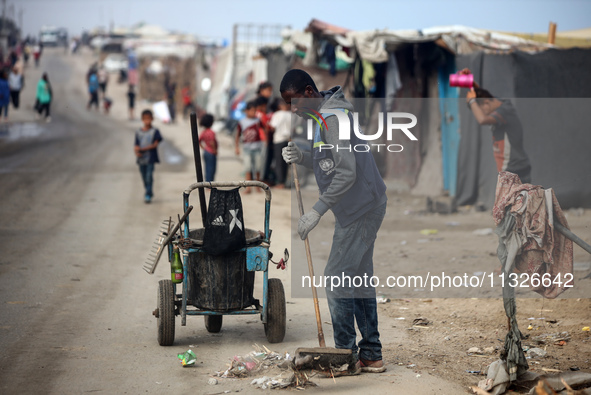 United Nations Agency for Palestinian Refugees (UNRWA) workers are cleaning a street in Deir el-Balah, in the central Gaza Strip, on June 13...