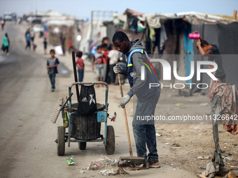 United Nations Agency for Palestinian Refugees (UNRWA) workers are cleaning a street in Deir el-Balah, in the central Gaza Strip, on June 13...