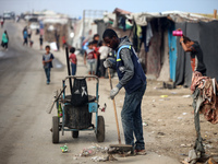 United Nations Agency for Palestinian Refugees (UNRWA) workers are cleaning a street in Deir el-Balah, in the central Gaza Strip, on June 13...